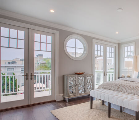 Ultra Series inswing French patio doors with Beige exterior finish, PDL bars, Antique Brass Toronto handle sets, mulled to sidelites and transoms.